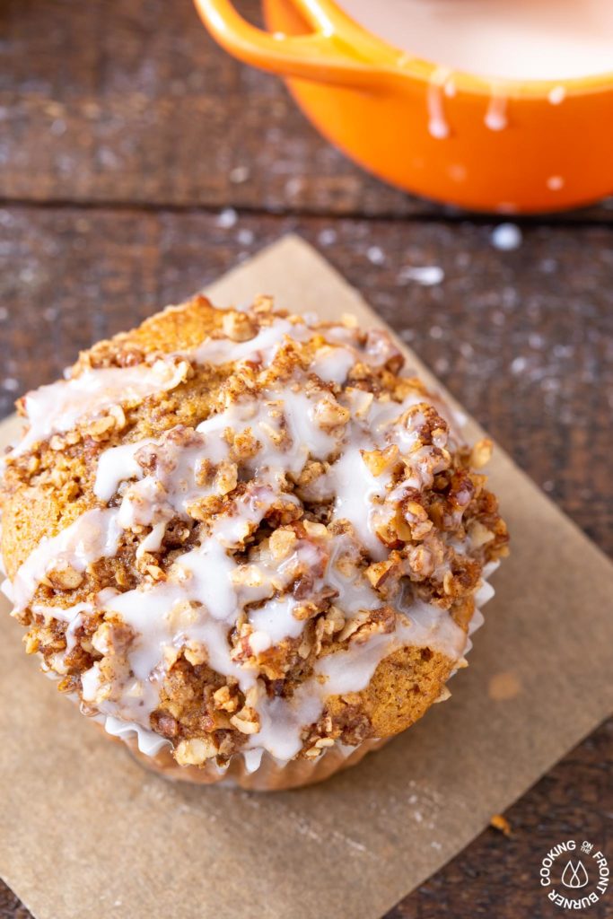 a close up of a pumpkin muffin with pecan streusel and glaze