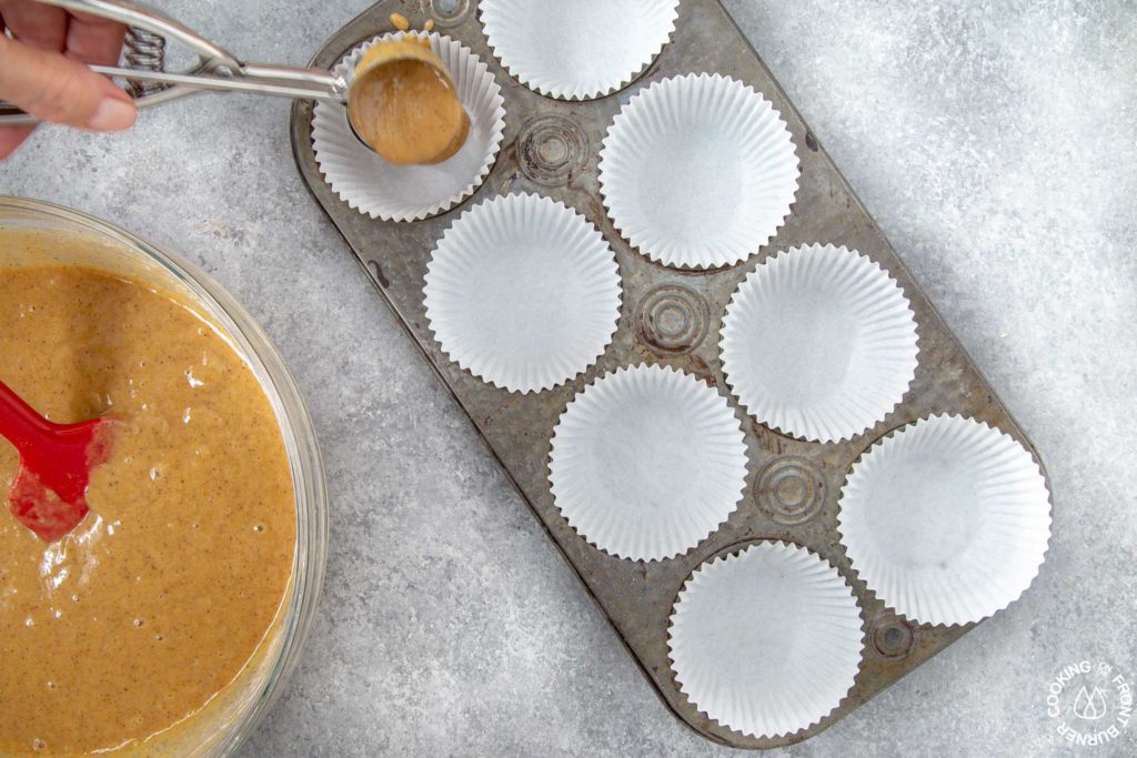 scooping batter into muffin tins