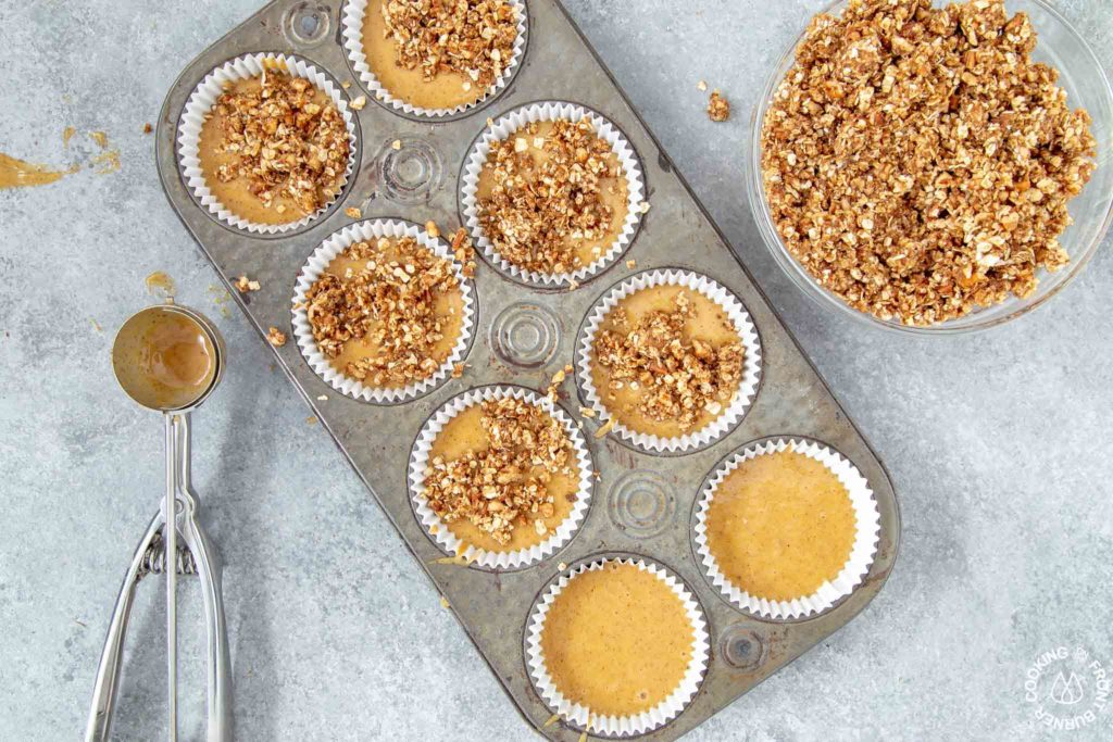 muffin tins with batter and streusel topping on top