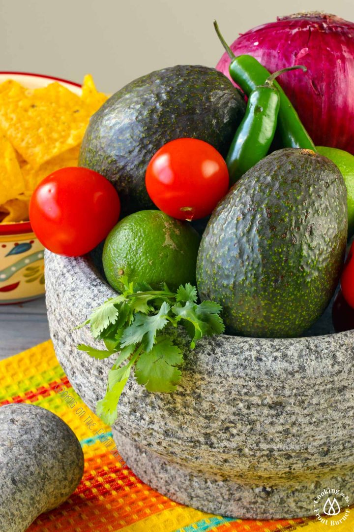 lines, avocados, cilantro tomatoes in a bowl