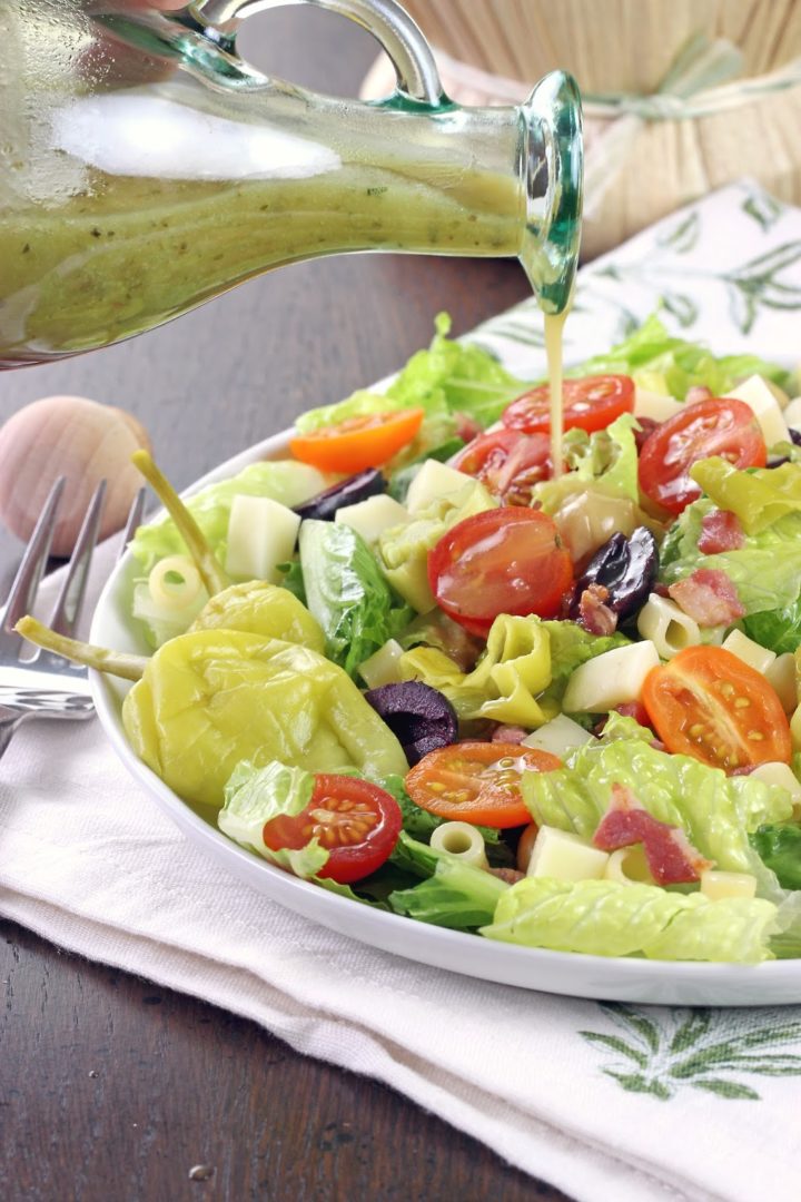 a bowl with lettuce, tomatoes, olives