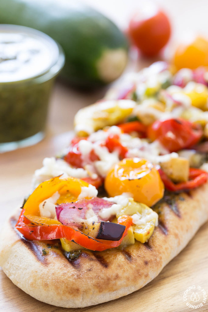 This Grilled Veggie Pesto Flatbread is a fresh take on traditional pizza. By starting with store bought naan bread, grilled vegetables, and homemade fresh pesto, this vegetarian flatbread is great for summer grilling!