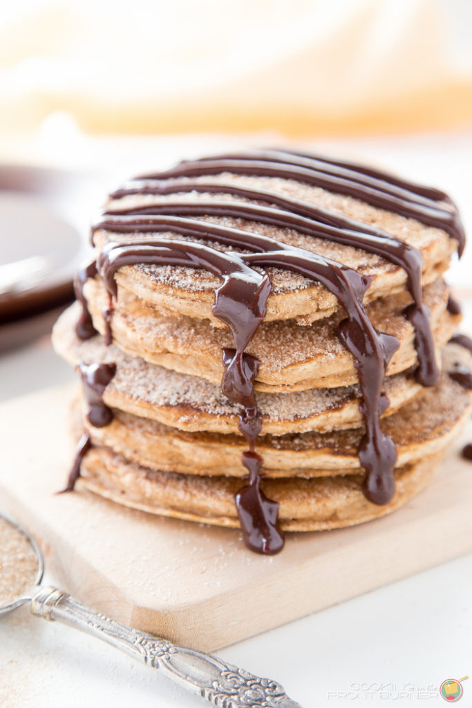 Churro Pancakes topped with a Spicy Chocolate sauce image churro pancakes on a serving board topped with chocolate sauce