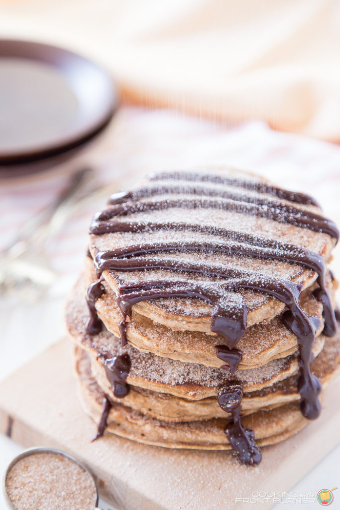 5 churro pancakes stacked with cinnamon sugar sprinkled on top