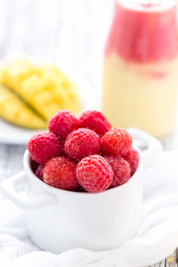 Start your day off right with this two toned Mango Raspberry Sunshine Yogurt Smoothie recipe. Easy to make and a healthy snack, too!