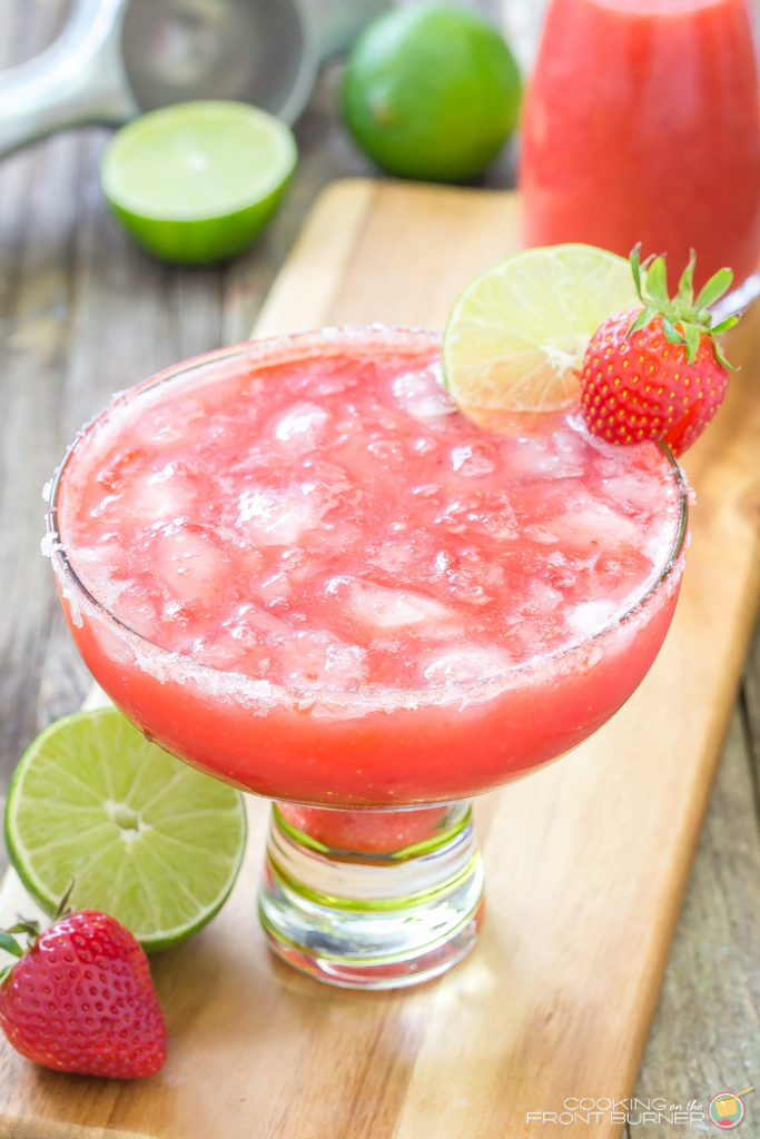 fresh strawberry margarita in a glass ono a serving board