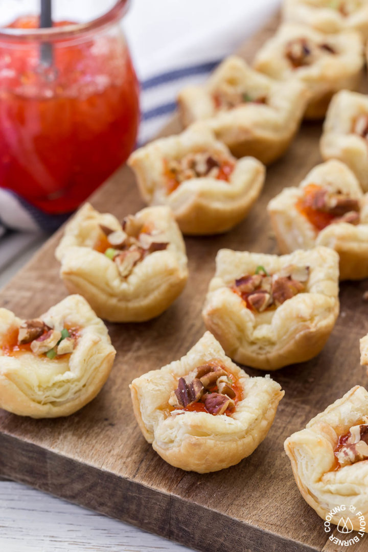 7 puff pastry appetizers on a brown cutting board