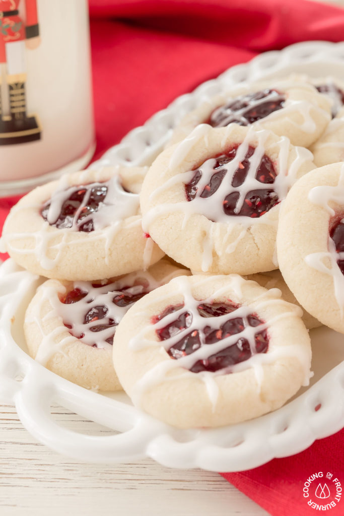 Your holiday cookie plate won't be complete unless you have these easy Raspberry Thumbprint Cookies with buttery shortbread, almond flavoring and glaze.  They look festive too! #christmascookies #shortbread