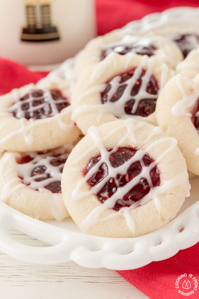 Your holiday cookie plate won't be complete unless you have these easy Raspberry Thumbprint Cookies with buttery shortbread, almond flavoring and glaze.  They look festive too! #christmascookies #shortbread