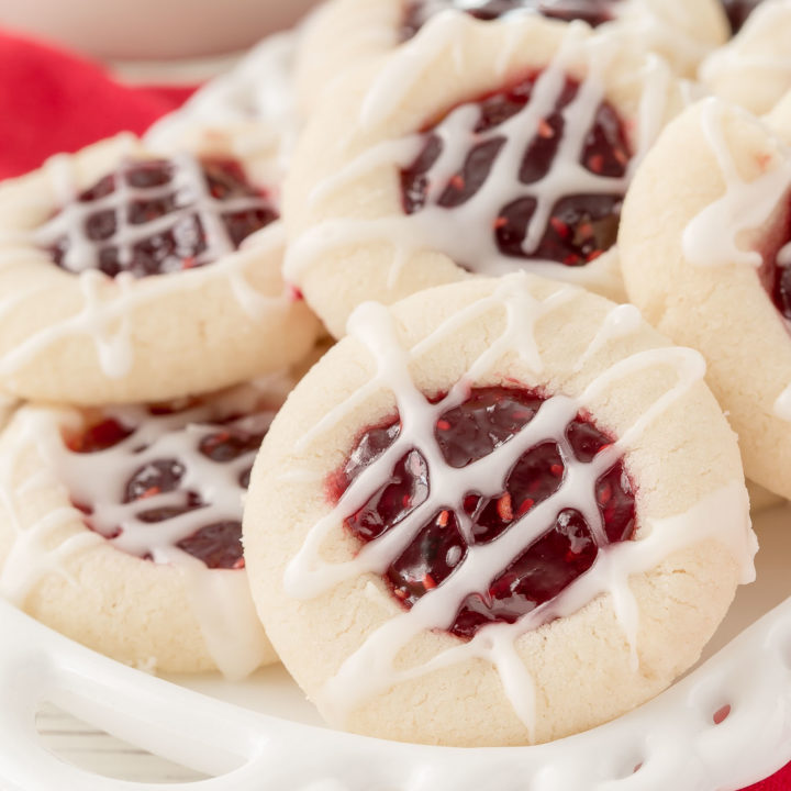 Your holiday cookie plate won't be complete unless you have these easy Raspberry Thumbprint Cookies with buttery shortbread, almond flavoring and glaze.  They look festive too! #christmascookies #shortbread