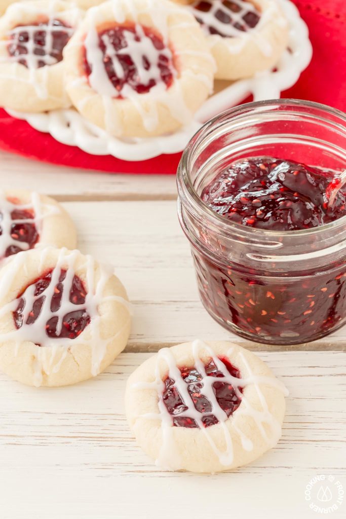 Your holiday cookie plate won't be complete unless you have these easy Raspberry Thumbprint Cookies with buttery shortbread, almond flavoring and glaze.  They look festive too! #christmascookies #shortbread