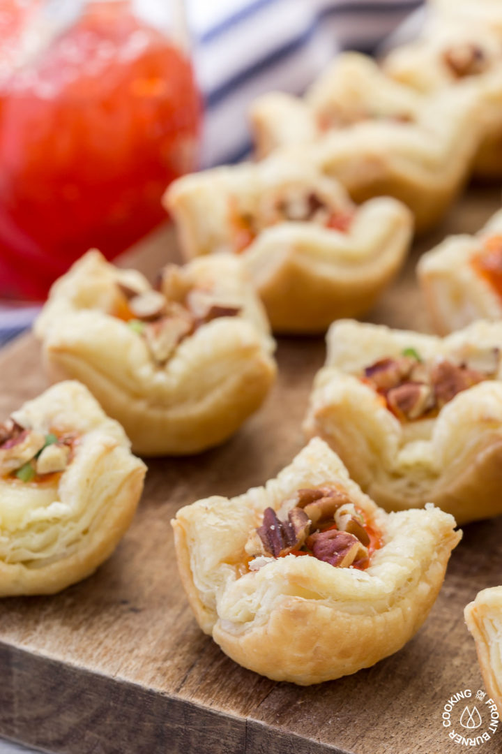 Brie hot pepper jelly puffs on a brown cutting board