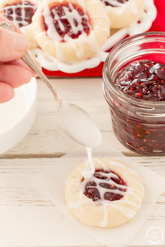 Your holiday cookie plate won't be complete unless you have these easy Raspberry Thumbprint Cookies with buttery shortbread, almond flavoring and glaze.  They look festive too! #christmascookies #shortbread