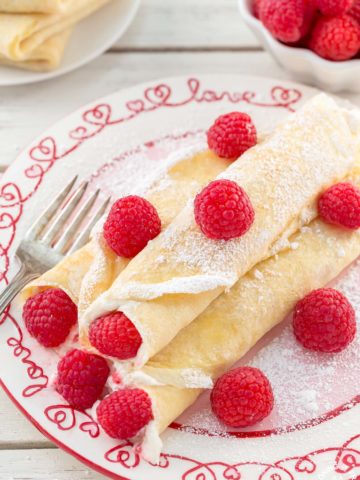 These Raspberry Vanilla Cream Crepes make the perfect dessert for Valentine's Day or any time you want to impress that someone special.  The crepes have a creamy vanilla filling and the fresh raspberries add a pop of color.