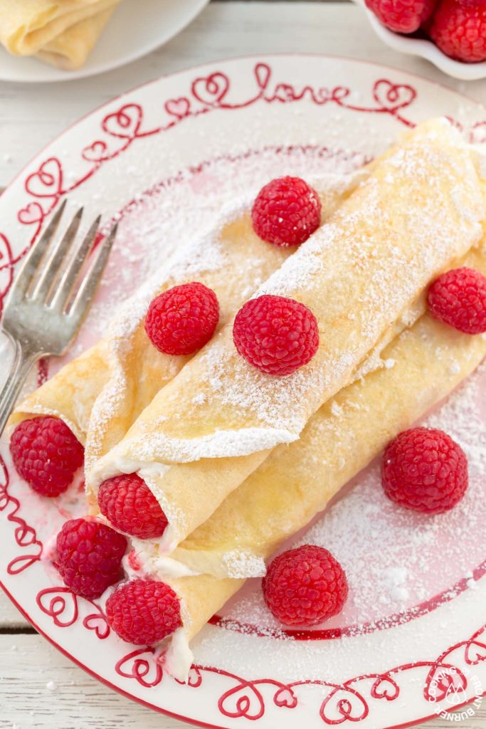These Raspberry Vanilla Cream Crepes make the perfect dessert for Valentine's Day or any time you want to impress that someone special.  The crepes have a creamy vanilla filling and the fresh raspberries add a pop of color.