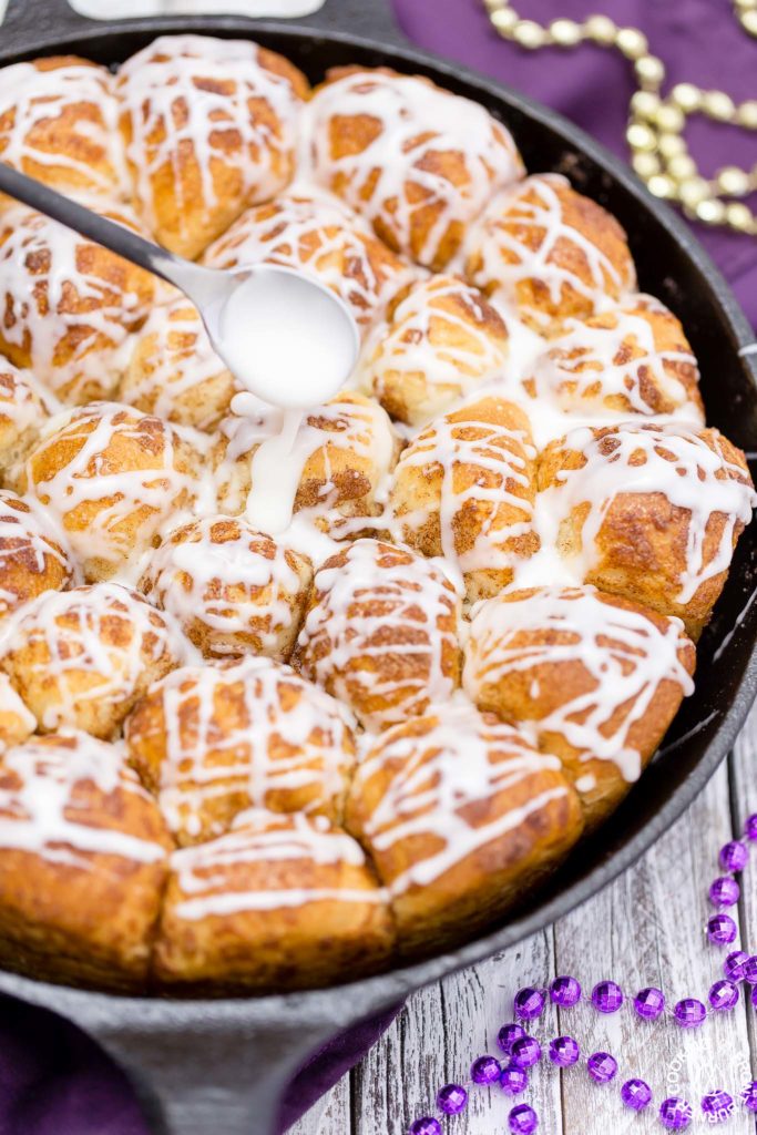 Your taste buds will be tantalized with these Skillet Cinnamon Rolls.  They are easy to make by starting with frozen rolls, the right amount of cinnamon and sugar and drizzled with a vanilla glaze.  Your kitchen will smell amazing too while they are baking! #breakfast #skilletrolls #cinnamon rolls