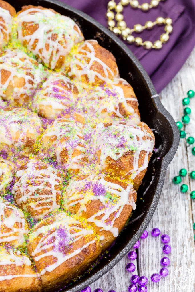 Your taste buds will be tantalized with these Skillet Cinnamon Rolls.  They are easy to make by starting with frozen rolls, the right amount of cinnamon and sugar and drizzled with a vanilla glaze.  Your kitchen will smell amazing too while they are baking! #breakfast #skilletrolls #cinnamon rolls #mardigras