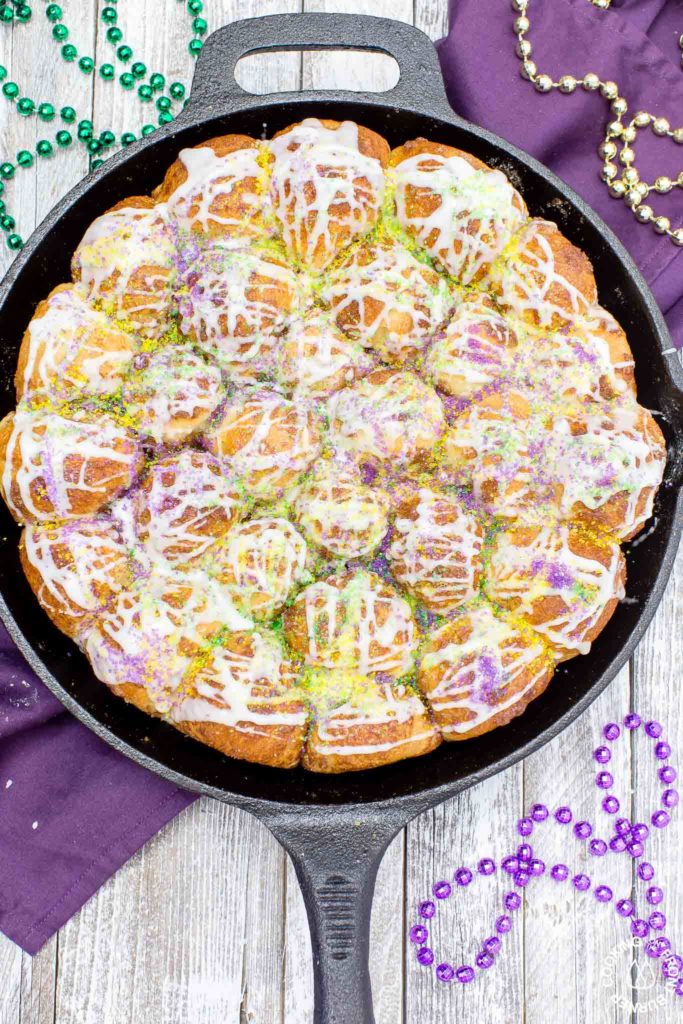 Your taste buds will be tantalized with these Skillet Cinnamon Rolls.  They are easy to make by starting with frozen rolls, the right amount of cinnamon and sugar and drizzled with a vanilla glaze.  Your kitchen will smell amazing too while they are baking! #breakfast #skilletrolls #cinnamon rolls #mardigras