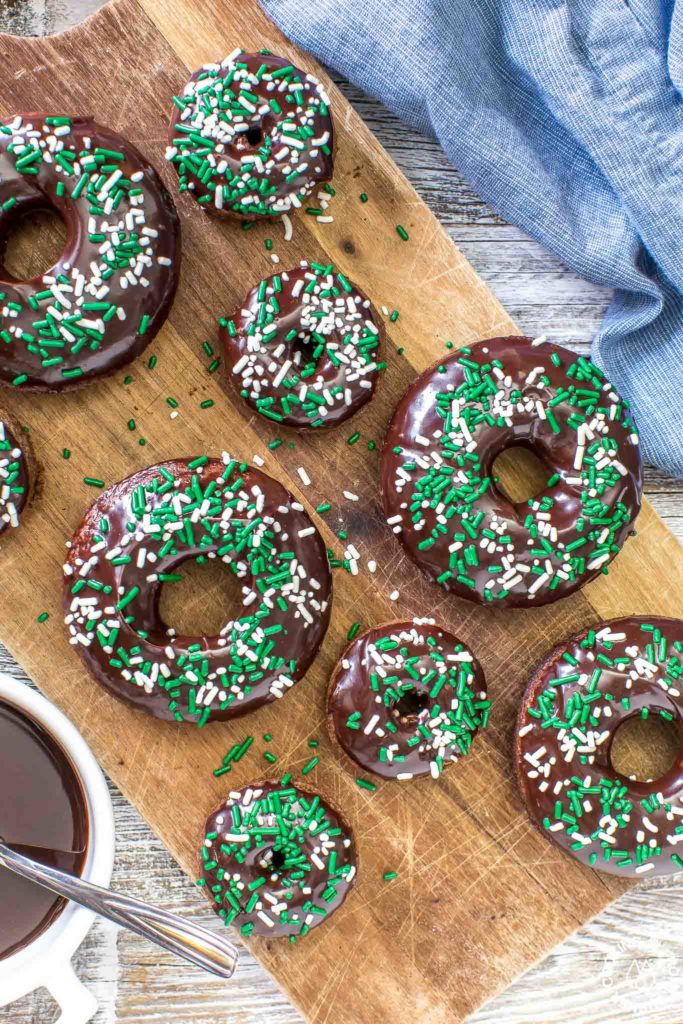 These chocolate Irish Cream Glazed Donuts are baked - not fried - and have a thick layer of chocolate ganache and festive sprinkles.  They are so easy to make and are perfect for breakfast for a sweet treat! #donuts #chocolate #ganache #irishcream #baked
