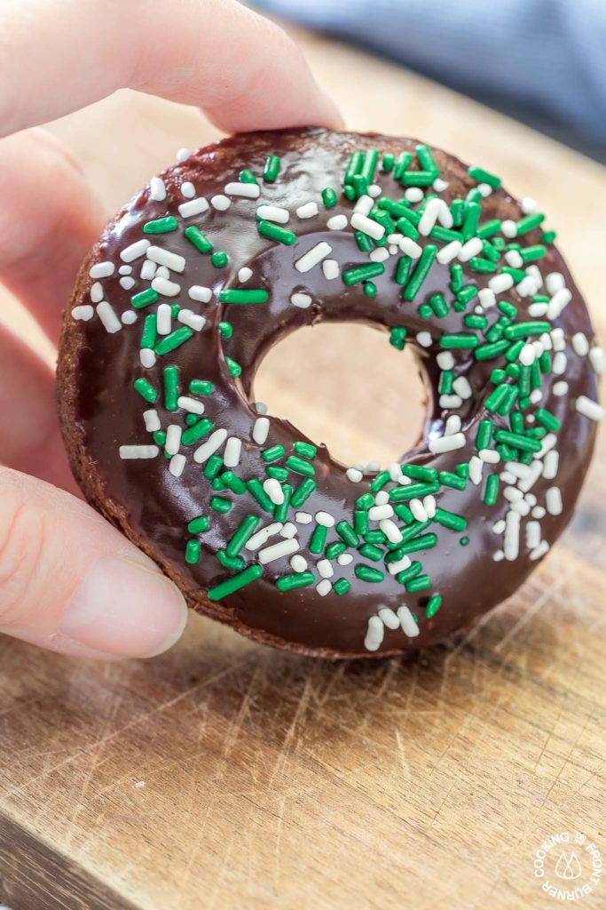 These chocolate Irish Cream Glazed Donuts are baked - not fried - and have a thick layer of chocolate ganache and festive sprinkles.  They are so easy to make and are perfect for breakfast for a sweet treat! #donuts #chocolate #ganache #irishcream #baked