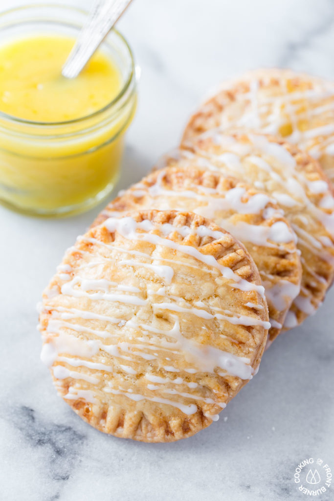 Don't these Lemon Curd Hand Pies look cute and fun to eat?  You will love the flaky crust, tangy lemon curd filling drizzled with a powdered sugar glaze.  The best part is they can be ready in under 30 minutes with 4 ingredients! #lemoncurd #handpies #dessert