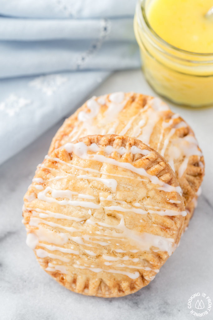 Don't these Lemon Curd Hand Pies look cute and fun to eat?  You will love the flaky crust, tangy lemon curd filling drizzled with a powdered sugar glaze.  The best part is they can be ready in under 30 minutes with 4 ingredients! #lemoncurd #handpies #dessert