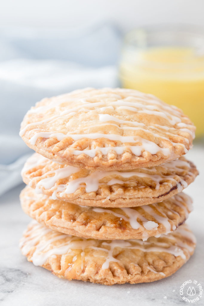 Don't these Lemon Curd Hand Pies look cute and fun to eat?  You will love the flaky crust, tangy lemon curd filling drizzled with a powdered sugar glaze.  The best part is they can be ready in under 30 minutes with 4 ingredients! #lemoncurd #handpies #dessert