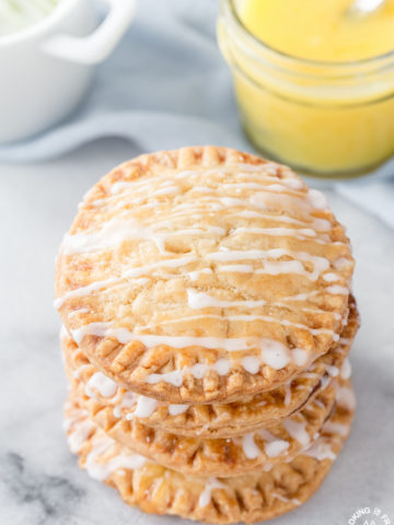 Don't these Lemon Curd Hand Pies look cute and fun to eat?  You will love the flaky crust, tangy lemon curd filling drizzled with a powdered sugar glaze.  The best part is they can be ready in under 30 minutes with 4 ingredients! #lemoncurd #handpies #dessert