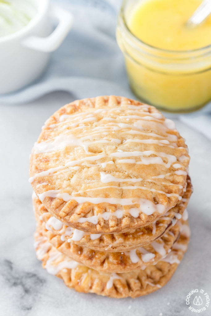 Don't these Lemon Curd Hand Pies look cute and fun to eat?  You will love the flaky crust, tangy lemon curd filling drizzled with a powdered sugar glaze.  The best part is they can be ready in under 30 minutes with 4 ingredients! #lemoncurd #handpies #dessert