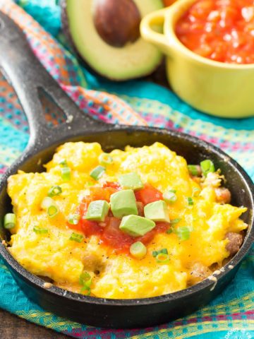 You live love waking up to this Mexican Breakfast Skillet Pizza that will be your favorite meal of the day! The skillet is lined with cripsy tator tots, lots of gooey cheese, sausage, eggs, green chilies and great toppings. #mexican #skillet #breakfastpizza