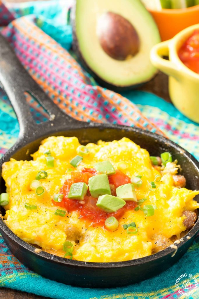 You will love waking up to this Mexican Breakfast Skillet Pizza that will be your favorite meal of the day! The skillet is lined with crispy tator tots, lots of gooey cheese, sausage, eggs, green chilies and great toppings. #mexican #skillet #breakfastpizza
