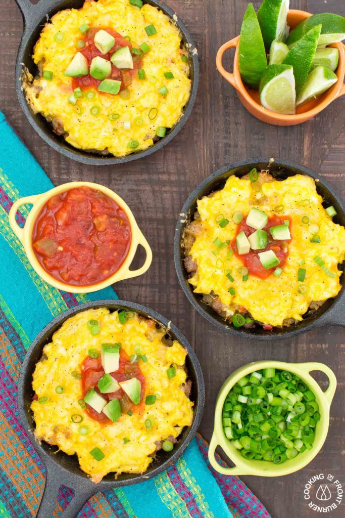 You will love waking up to this Mexican Breakfast Skillet Pizza that will be your favorite meal of the day! The skillet is lined with crispy tator tots, lots of gooey cheese, sausage, eggs, green chilies and great toppings. #mexican #skillet #breakfastpizza