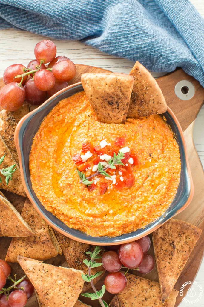 This Roasted Red Pepper Dip is an easy as throwing all the ingredients in a food processor, giving it a 30 second whirl and on your table in no time.  The Mediterranean flavors are perfect with toasted pita bread that you can also season up and bake as dippers. #redpepperdip #appetizer