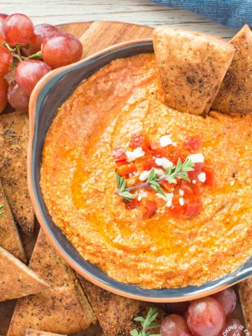 This Roasted Red Pepper Dip is an easy as throwing all the ingredients in a food processor, giving it a 30 second whirl and on your table in no time.  The Mediterranean flavors are perfect with toasted pita bread that you can also season up and bake as dippers. #redpepperdip #appetizer