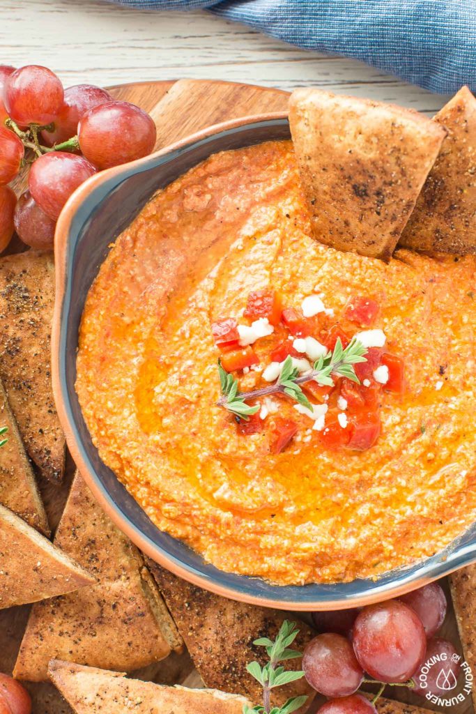 This Roasted Red Pepper Dip is an easy as throwing all the ingredients in a food processor, giving it a 30 second whirl and on your table in no time.  The Mediterranean flavors are perfect with toasted pita bread that you can also season up and bake as dippers. #redpepperdip #appetizer