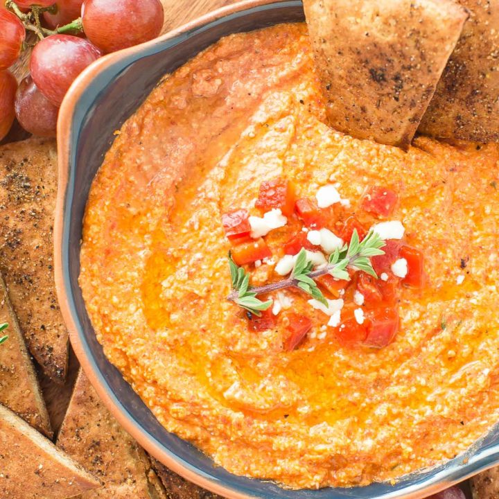 This Roasted Red Pepper Dip is an easy as throwing all the ingredients in a food processor, giving it a 30 second whirl and on your table in no time.  The Mediterranean flavors are perfect with toasted pita bread that you can also season up and bake as dippers. #redpepperdip #appetizer