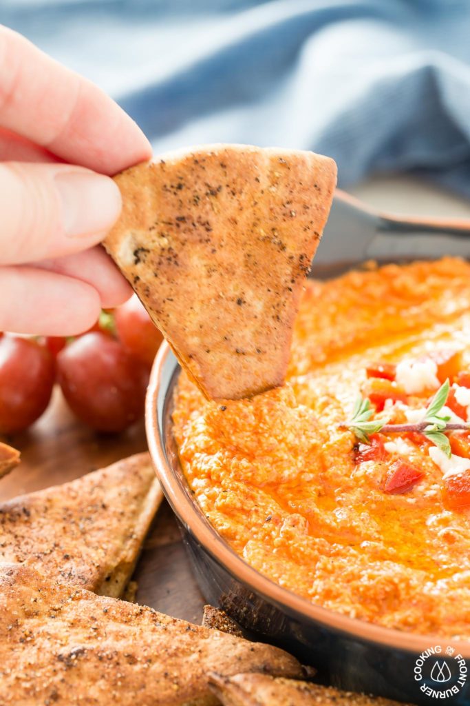 This Roasted Red Pepper Dip is an easy as throwing all the ingredients in a food processor, giving it a 30 second whirl and on your table in no time.  The Mediterranean flavors are perfect with toasted pita bread that you can also season up and bake as dippers. #redpepperdip #appetizer