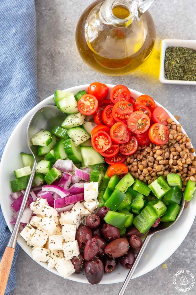 greek salad in a bowl with 2 spoons