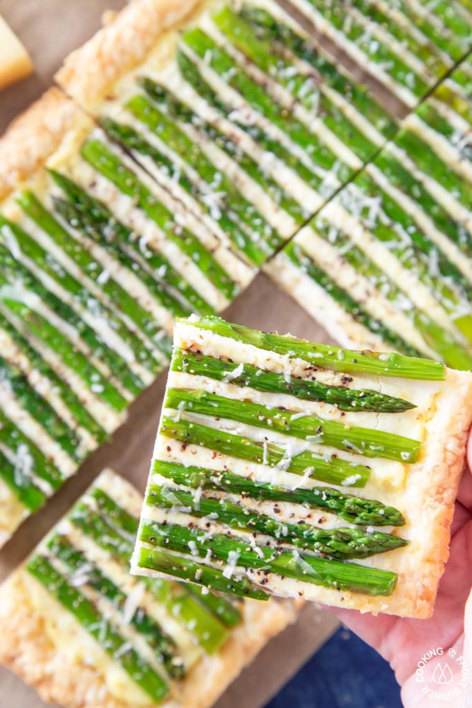 a slice of asparagus tart on a hand