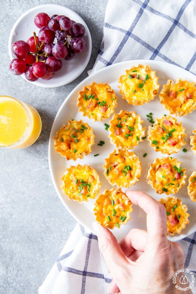 taking a mini quiche off a plate