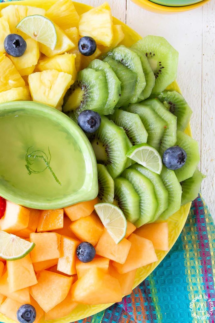 yellow platter with cut up kiwi and cantaloupe 