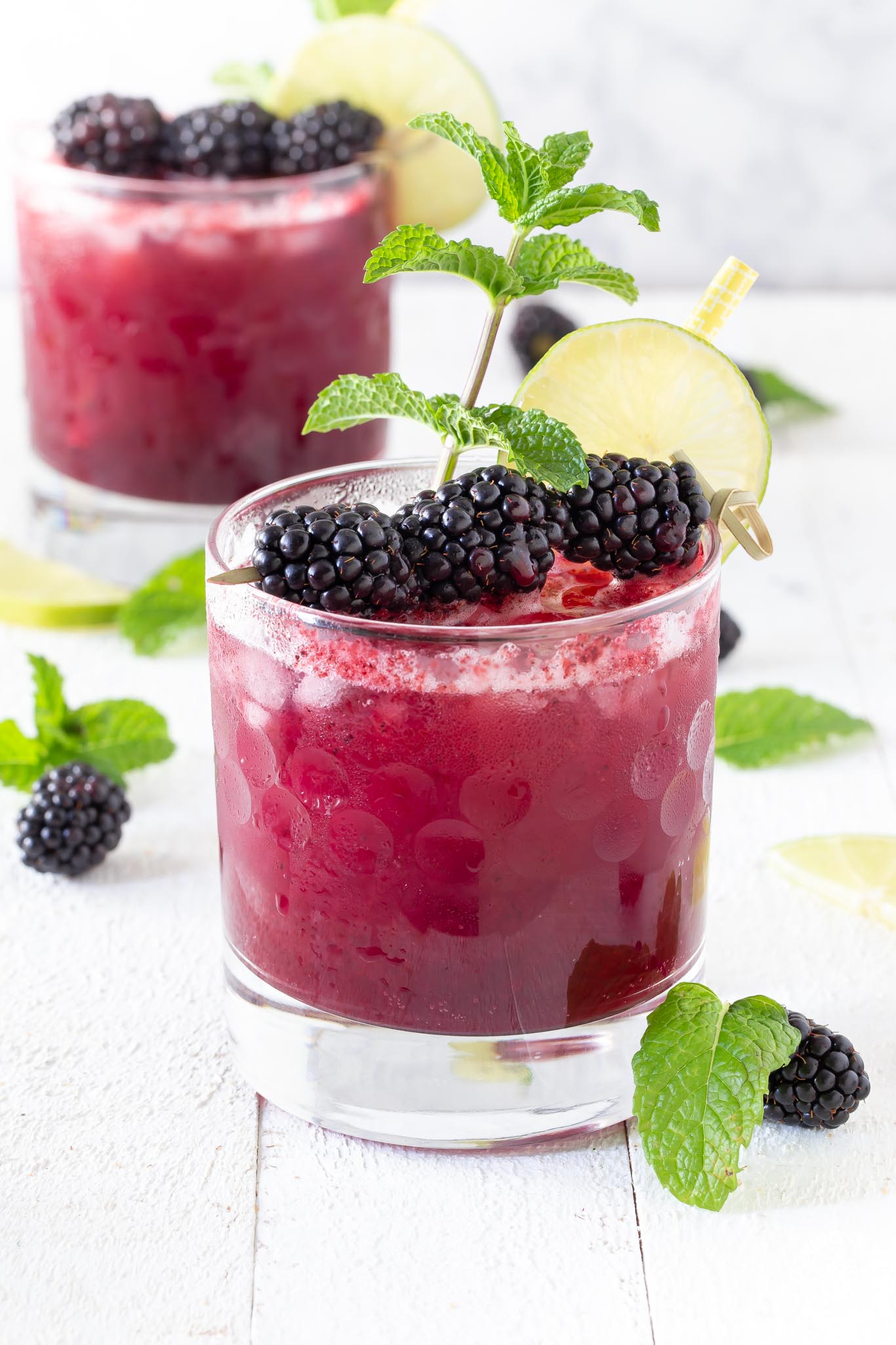 glass with blackberry bramble garnished with blackberries and mint sprig