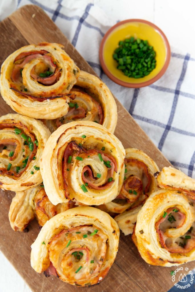 ham and cheese pinwheels piled on a cutting board