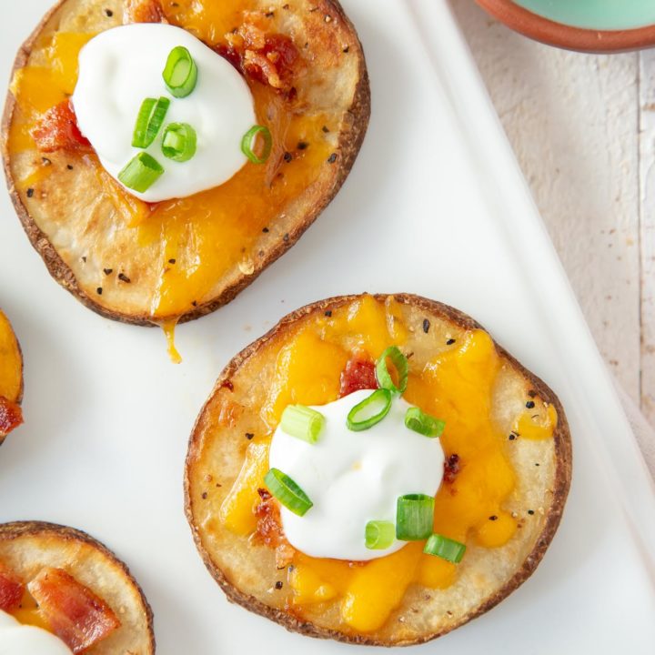 close up of loaded potato rounds on a white platter