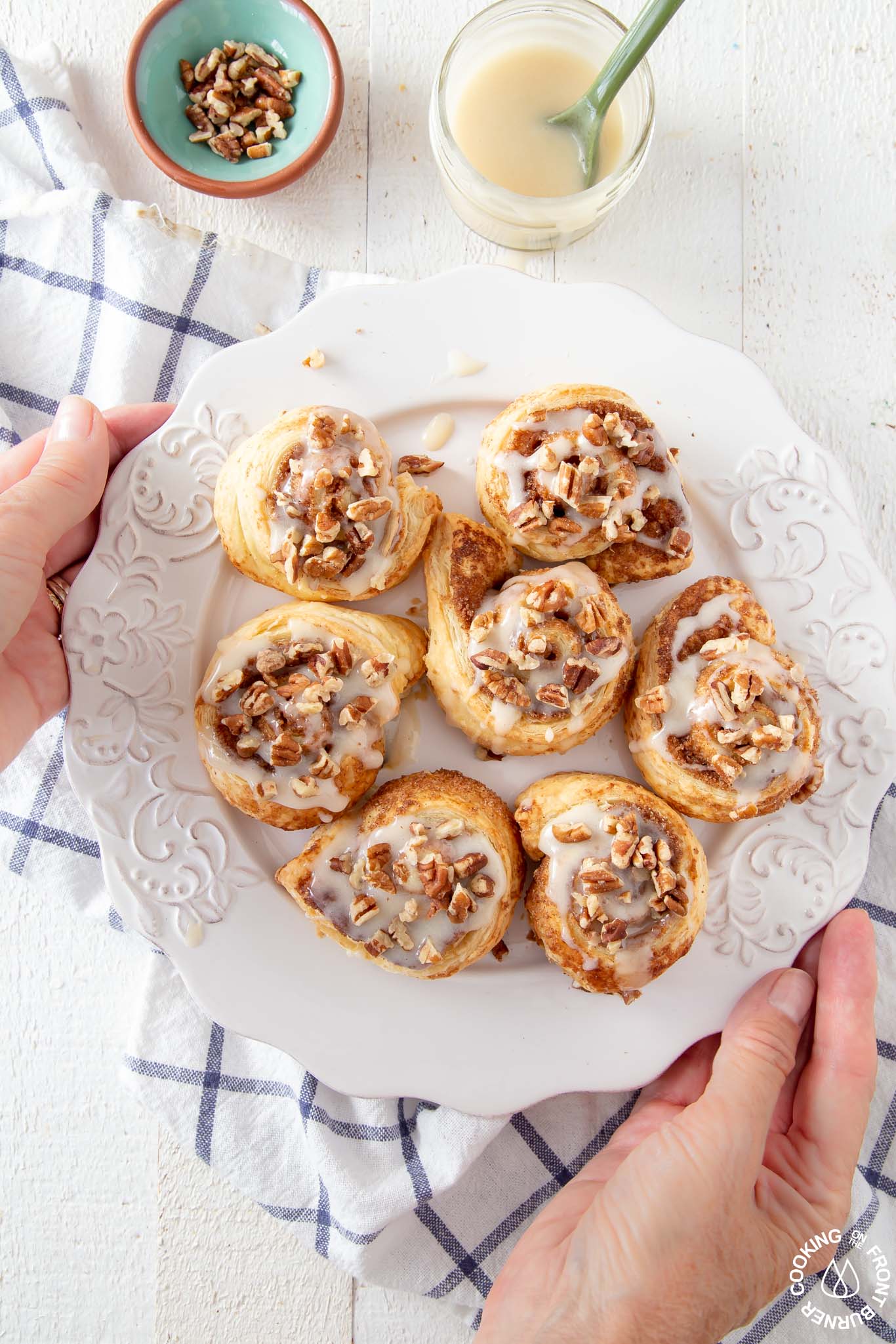 hands holding a plate of pumpkin spice rolls