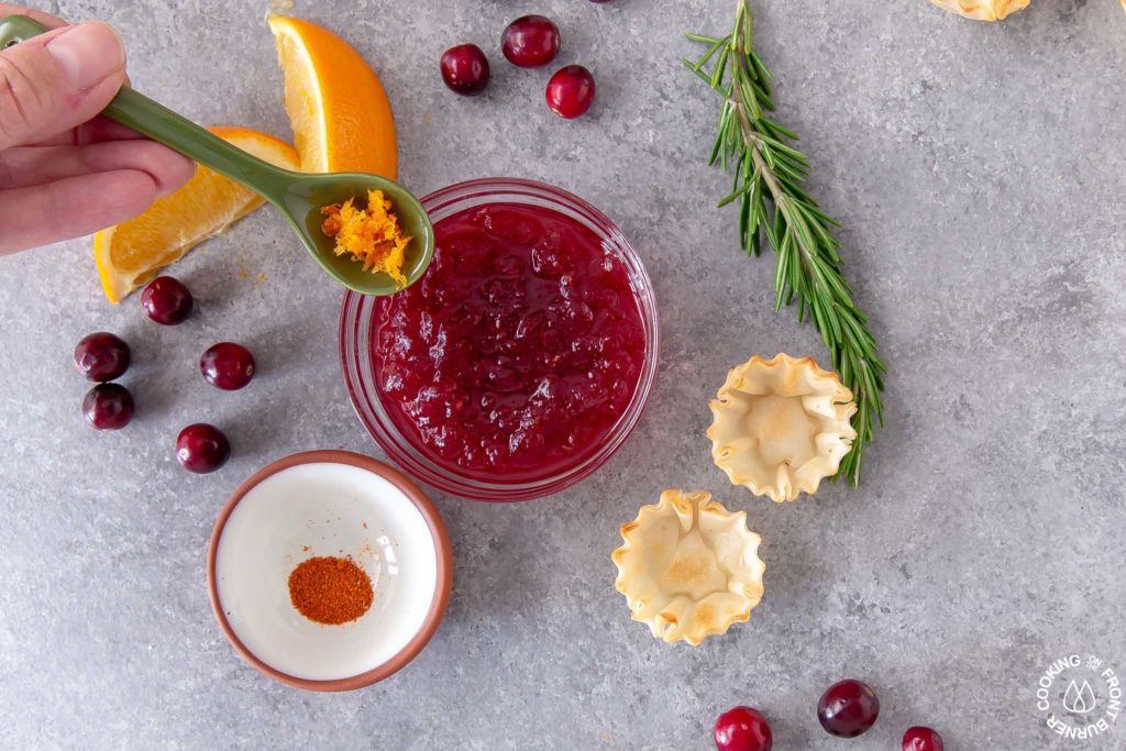 stirring orange zest into cranberry sauce