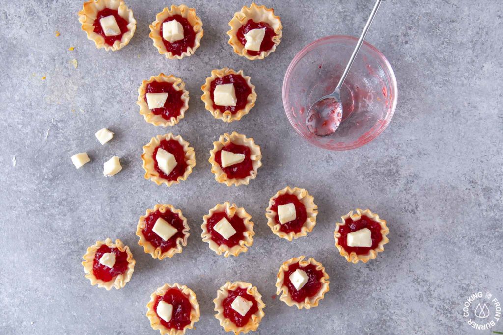 unbaked cranberry tarts on a board