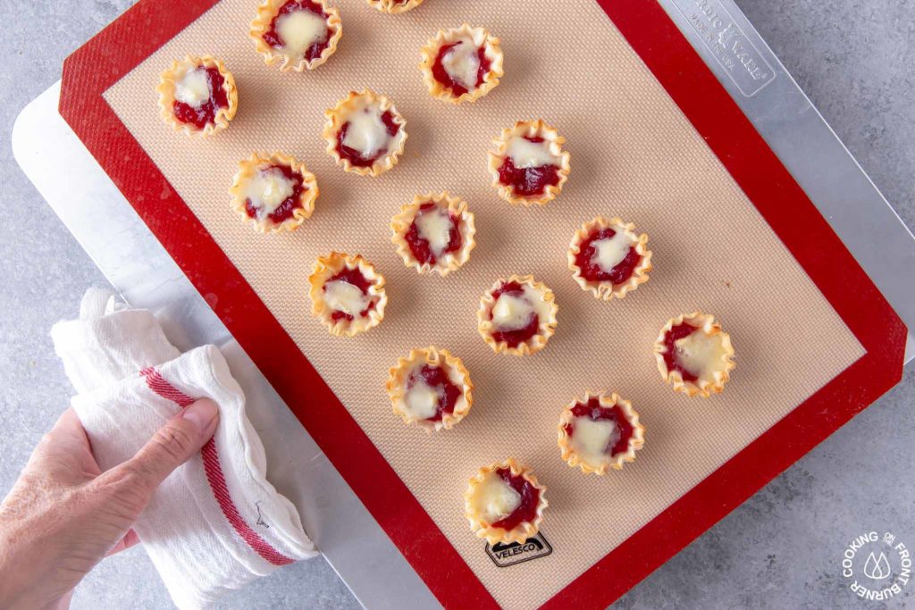 baked cranberry orange brie tarts on a cookie sheet
