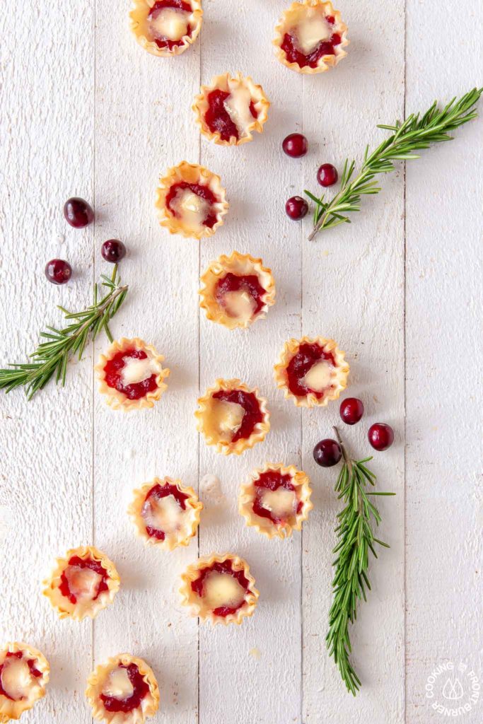 cranberry orange brie tarts on a board