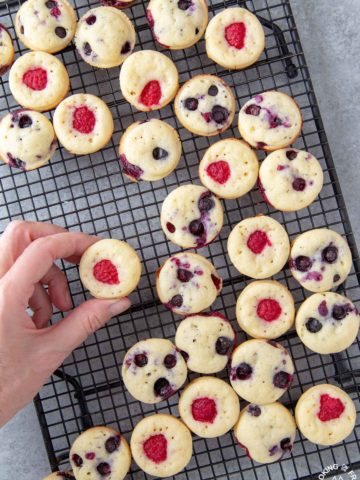 a hand taking a mini pancake muffin off a baking rack